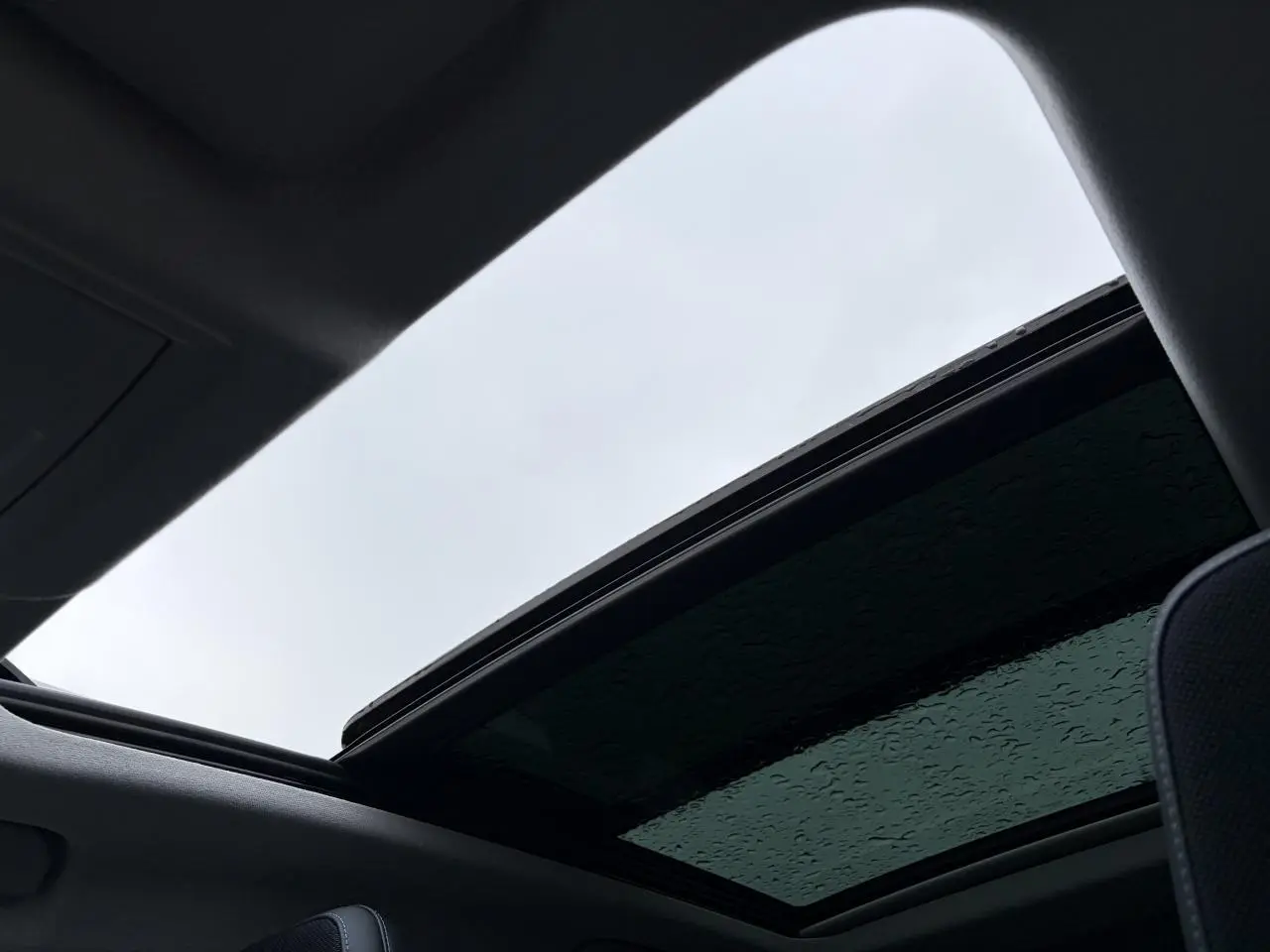 Vue intérieure du toit ouvrant panoramique vitré noir du Citroën C5 Aircross Platinium 2026 avec ciel gris visible.