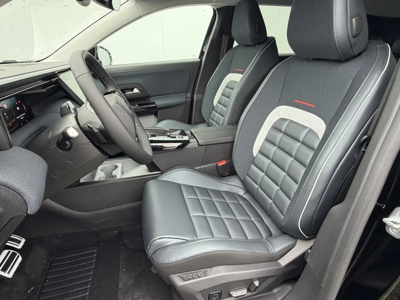 Vue intérieure côté conducteur du Citroën C5 Aircross 2026, sièges en cuir et tissu noir avec surpiqûres blanches.