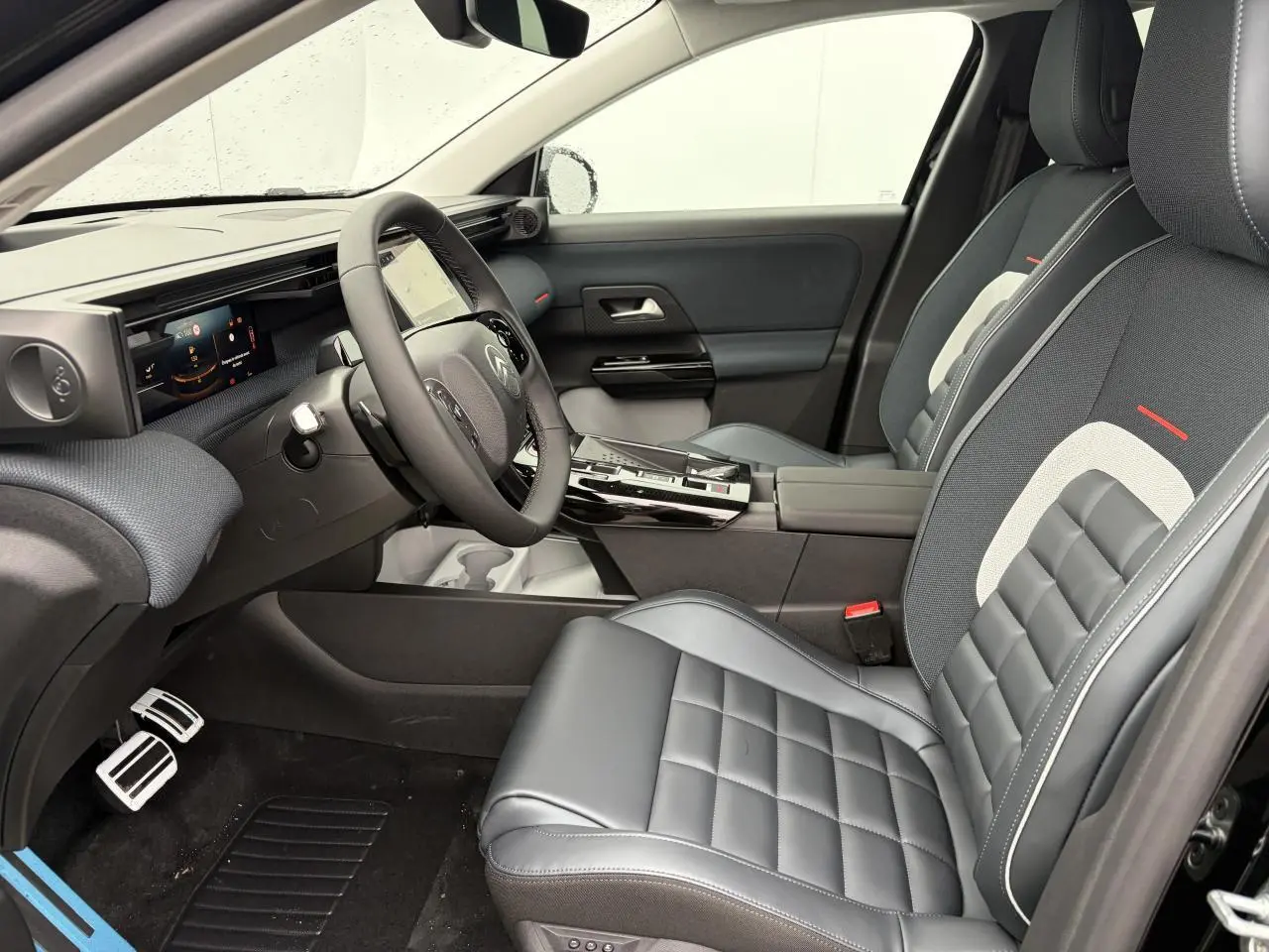 Vue intérieure côté conducteur du Citroën C5 Aircross 2026, sièges cuir et tissu gris avec surpiqûres blanches et rouges.
