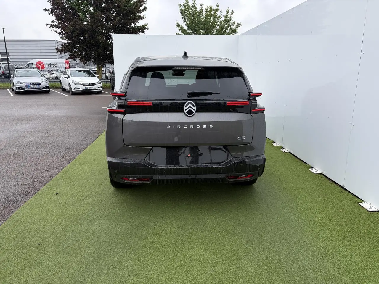 Vue arrière d'un Citroën C5 Aircross 2026 gris Platinium avec toit noir et feux arrière LED horizontaux distinctifs.