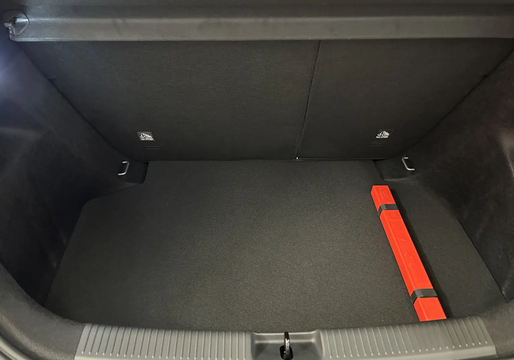Coffre ouvert de MG3 1.5 Hybrid+ 195 Luxury en Hampstead Grey, intérieur noir avec triangle de signalisation rouge.