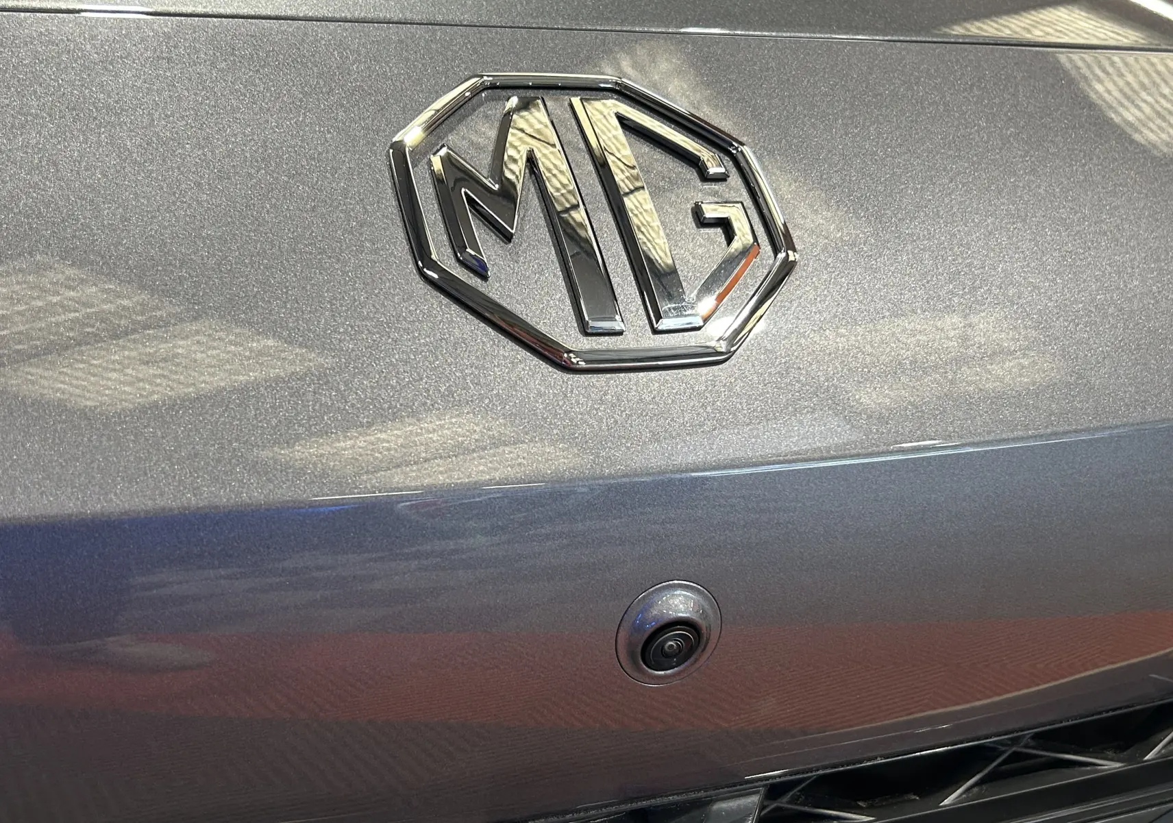 Gros plan sur le logo MG et la caméra 360° intégrée sur la calandre grise Hampstead du MG3 1.5 Hybrid+ 195 LUXURY 2026.