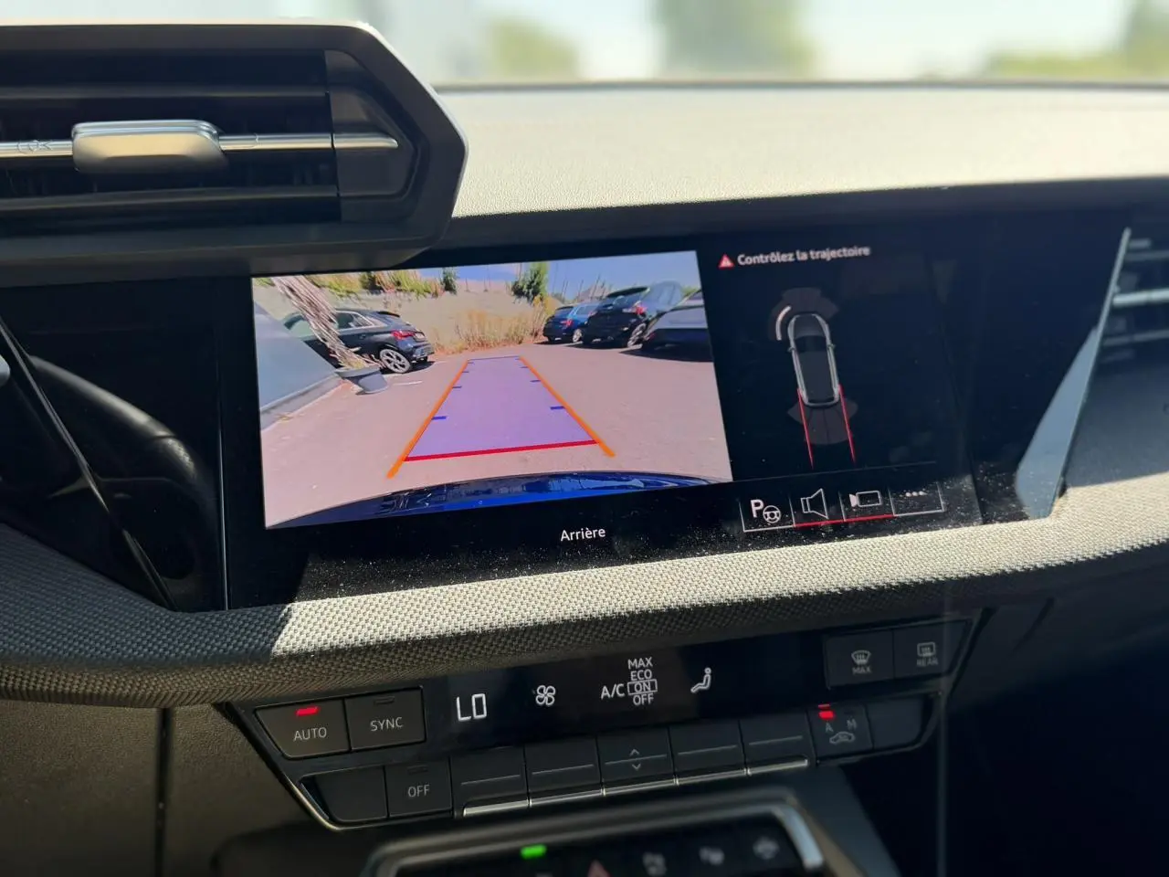 Vue rapprochée de l'écran central affichant la caméra de recul et l'aide au stationnement de l'Audi A3 Sportback Bleu Navarre.
