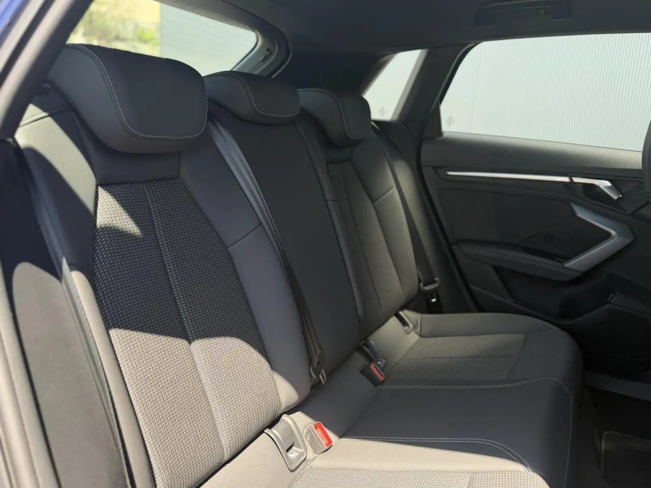 Vue intérieure côté droit des sièges arrière noirs en tissu et cuir de l'Audi A3 Sportback 2025.