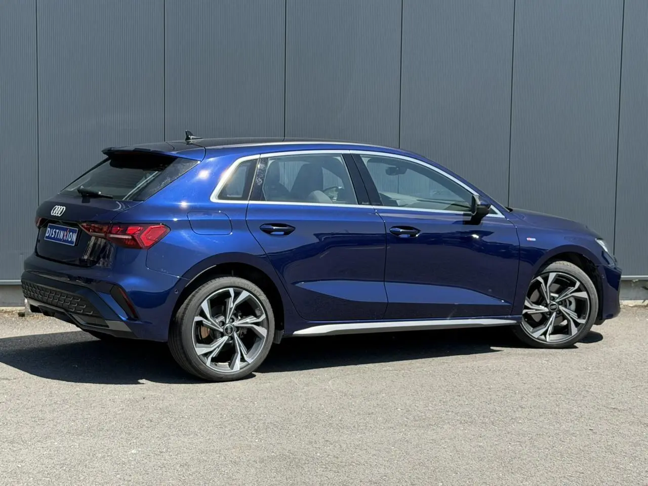 Audi A3 Sportback bleu Navarre vue de profil côté gauche, avec jantes alliage 5 branches en Y et toit noir.