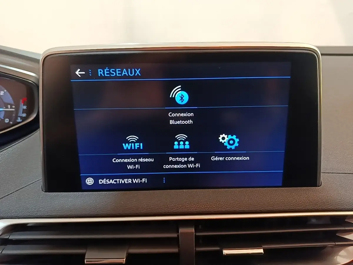 Écran tactile central du tableau de bord du Peugeot 5008 noir, affichant les options de connexion réseau Bluetooth et Wi-Fi.