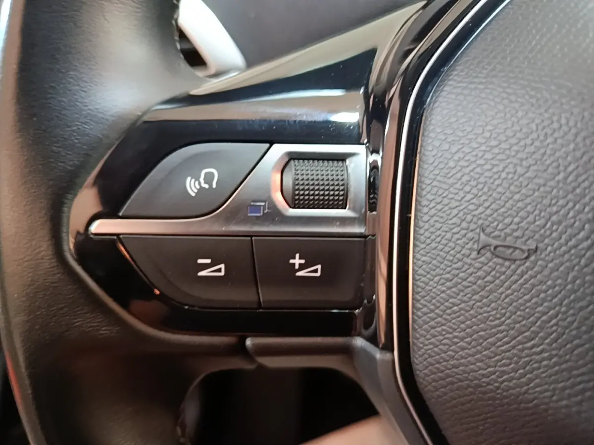 Gros plan sur les commandes vocales et volume au volant cuir noir du Peugeot 5008 BlueHDi 130 S&S Allure Business 2018.