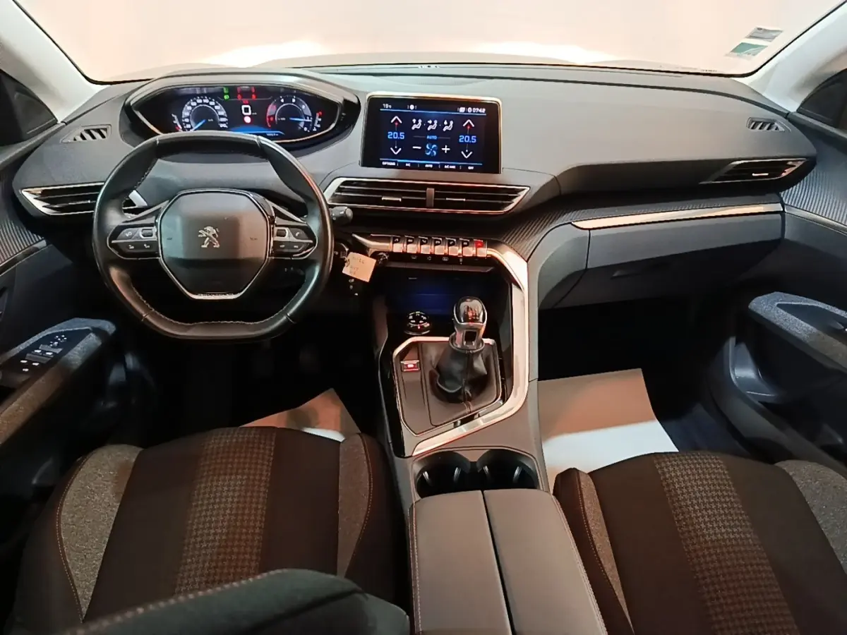 Vue intérieure avant du Peugeot 5008 2018 noir, tableau de bord avec écran tactile et volant multifonctions cuir.