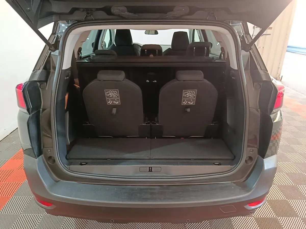 Vue arrière ouverte du Peugeot 5008 noir montrant les sièges arrière individuels et le coffre spacieux.