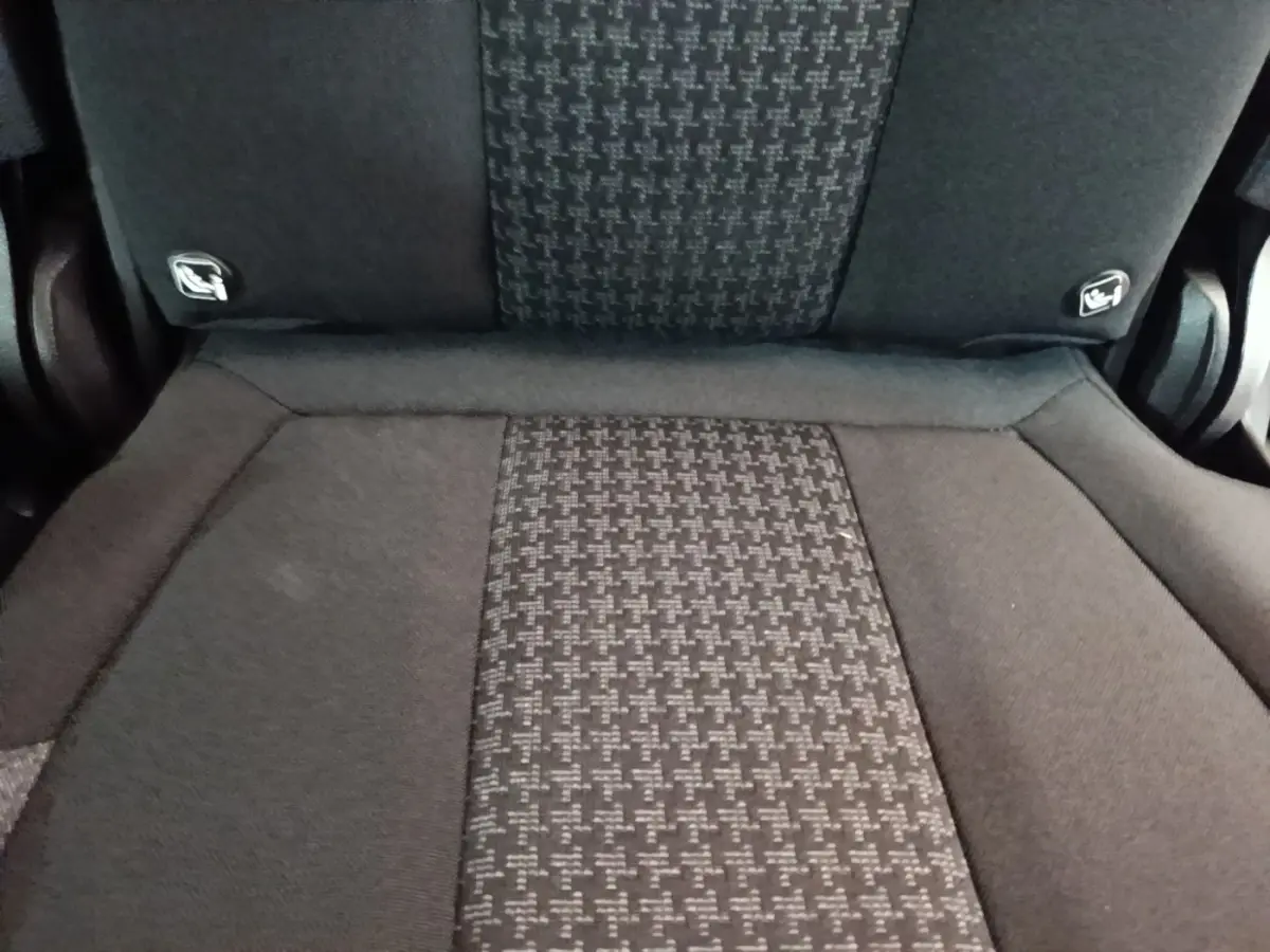 Gros plan sur la banquette arrière noire du Peugeot 5008 2018 avec motifs tissés et fixations Isofix visibles.