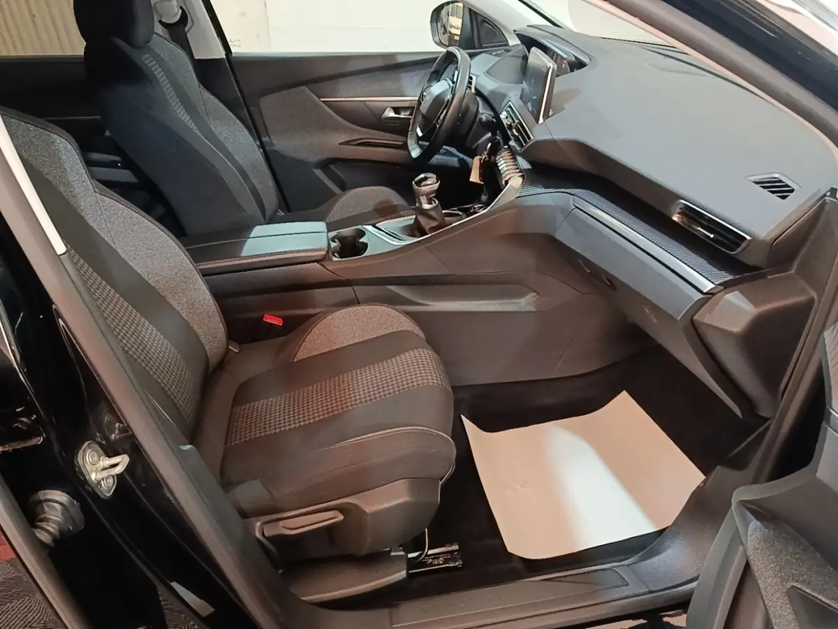 Intérieur avant droit du Peugeot 5008 noir 2018, sièges tissu gris et console centrale avec boîte manuelle.