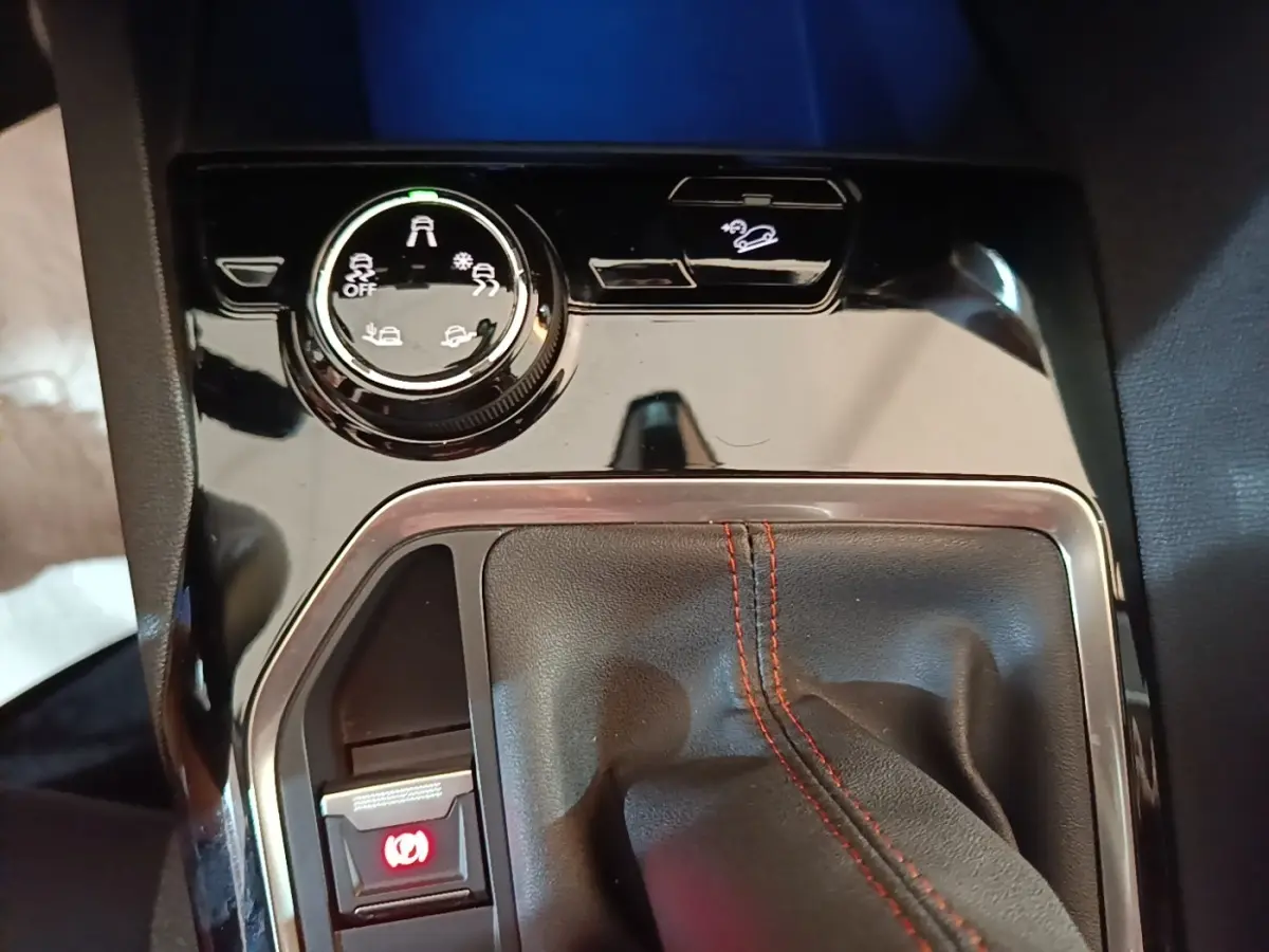 Gros plan sur la console centrale noire du Peugeot 5008 avec levier de vitesse manuel et commandes d’aide à la conduite.