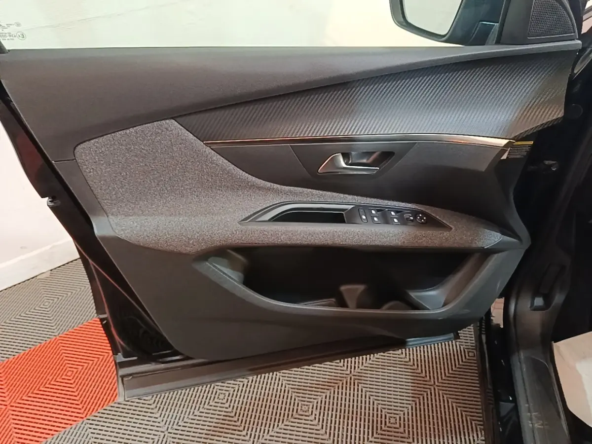 Vue rapprochée de la porte avant gauche noire du Peugeot 5008 2018, avec commandes des vitres et insert décoratif gris.