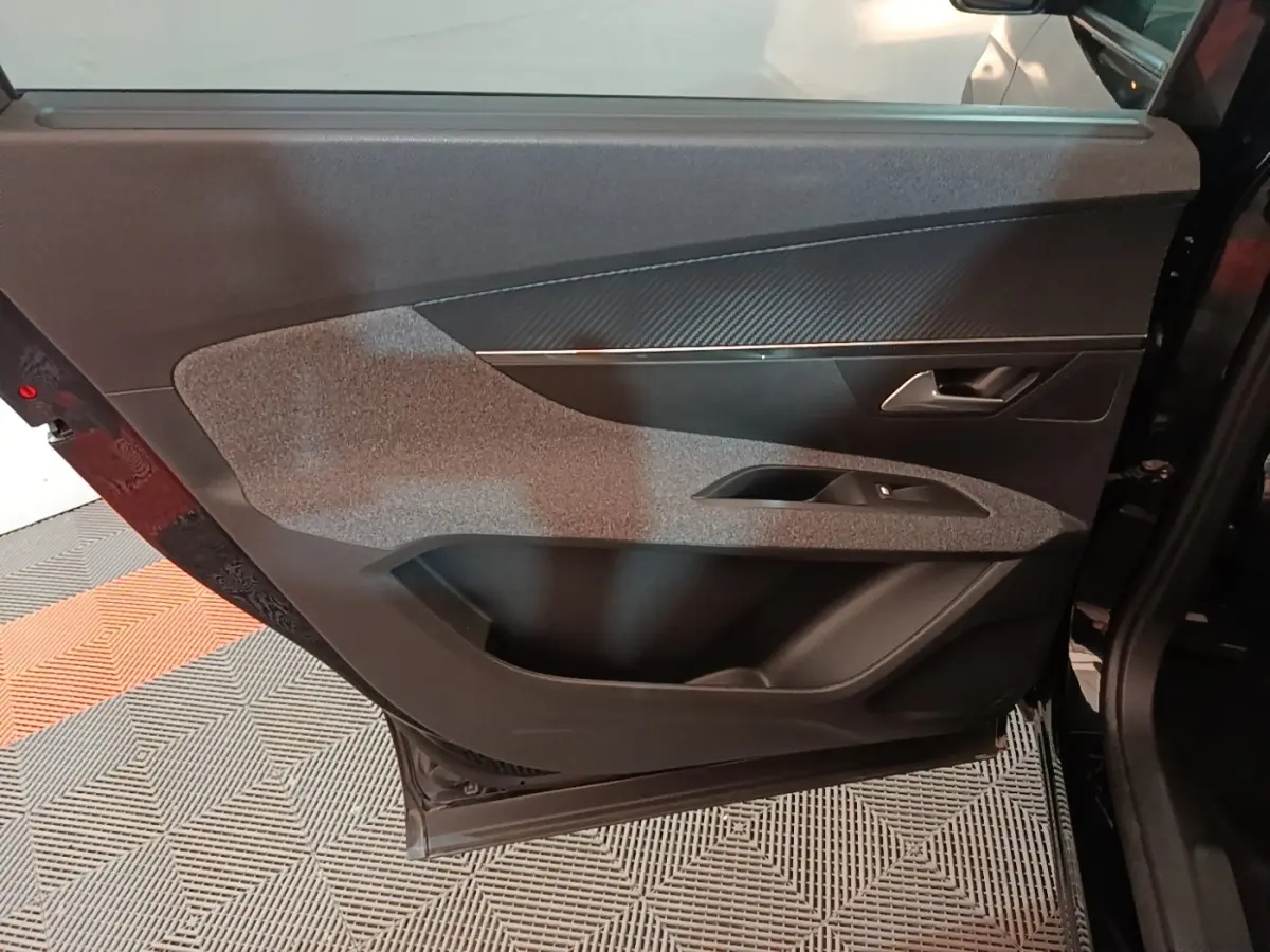 Vue intérieure de la porte arrière droite noire du Peugeot 5008 avec garniture grise et poignée argentée.