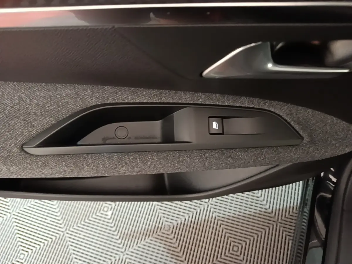 Détail de la poignée intérieure côté conducteur du Peugeot 5008 noir, avec bouton de verrouillage des portes.