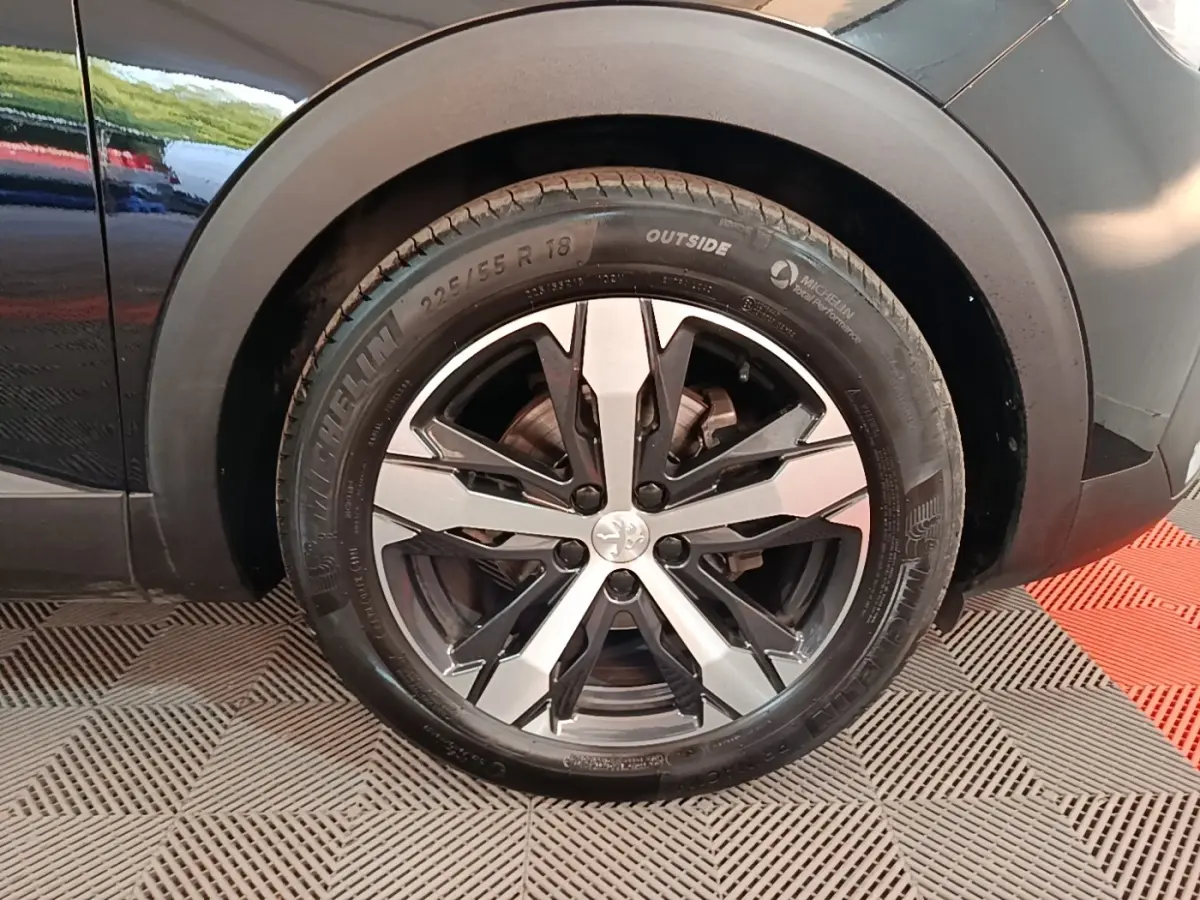 Gros plan sur la roue arrière droite noire du Peugeot 5008 avec jante alliage bicolore et pneu Michelin.