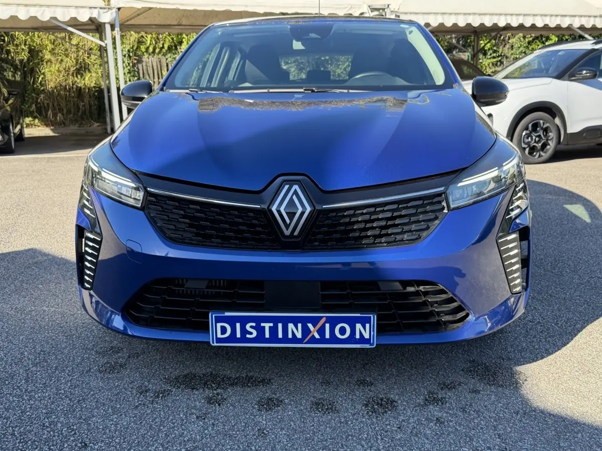 Vue frontale d'une Renault Clio Evolution TCe 90 bleu avec calandre noire et feux LED distinctifs.