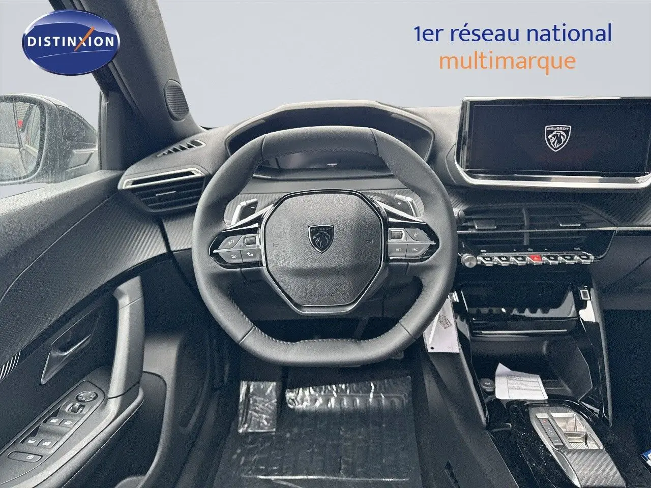 Intérieur du Peugeot 2008 Hybrid 2025, vue centrée sur le volant cuir noir et l'écran tactile moderne.