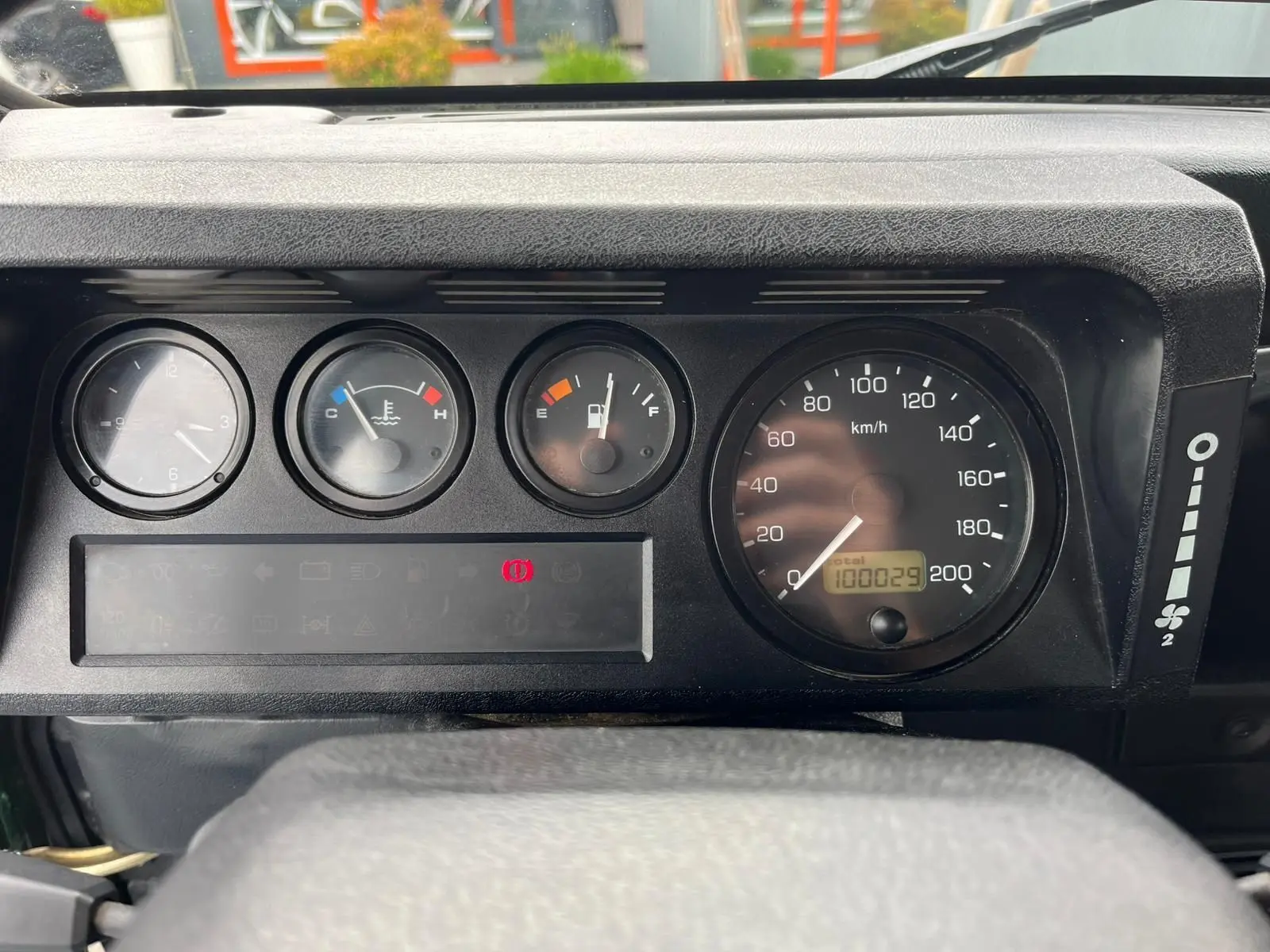 Tableau de bord du Land Rover Defender 90 2004, montrant les compteurs analogiques et l'odomètre à 100029 km.