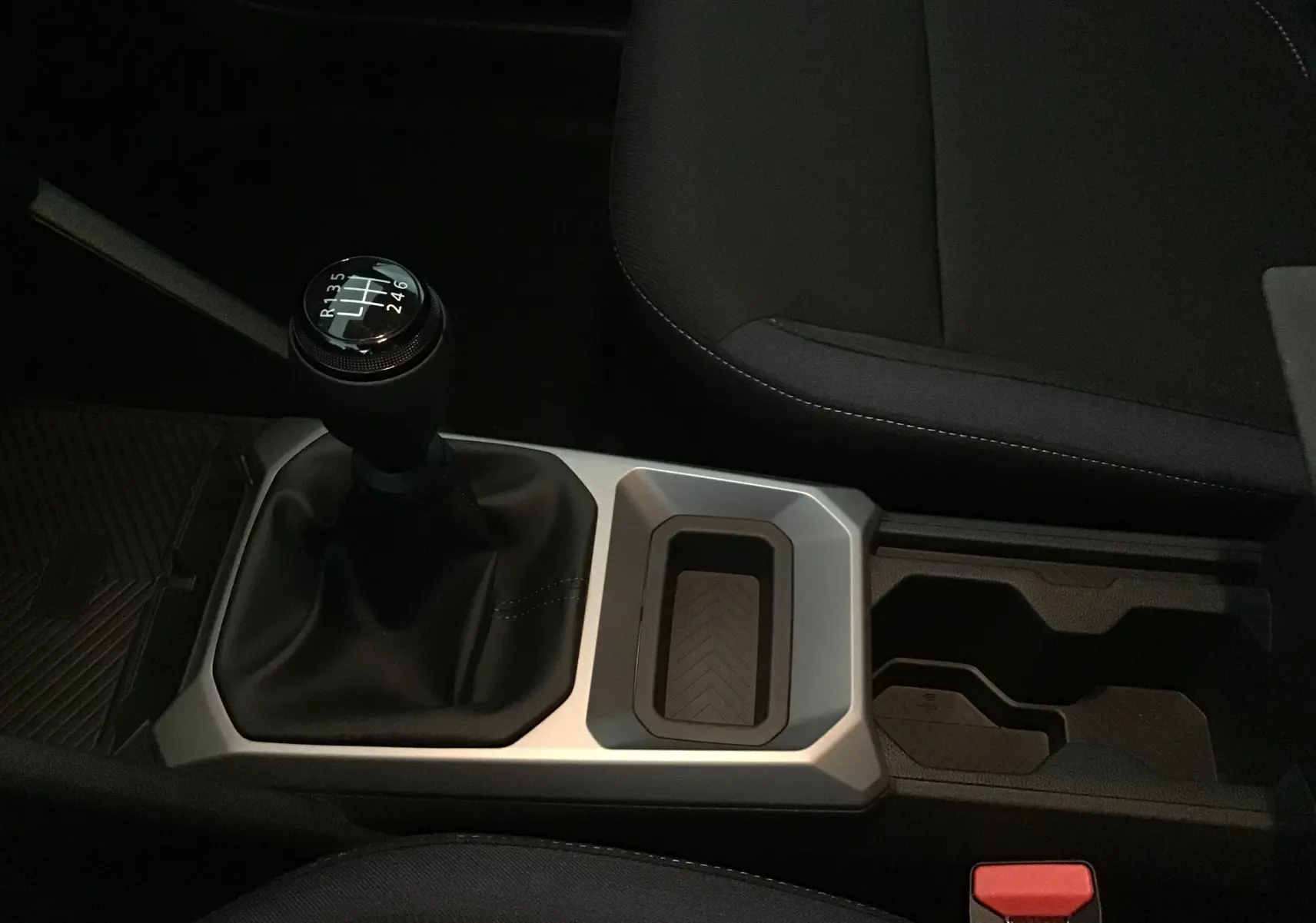 Vue rapprochée de la console centrale du Dacia Duster 2025 avec levier de vitesses manuel et porte-gobelets noirs.