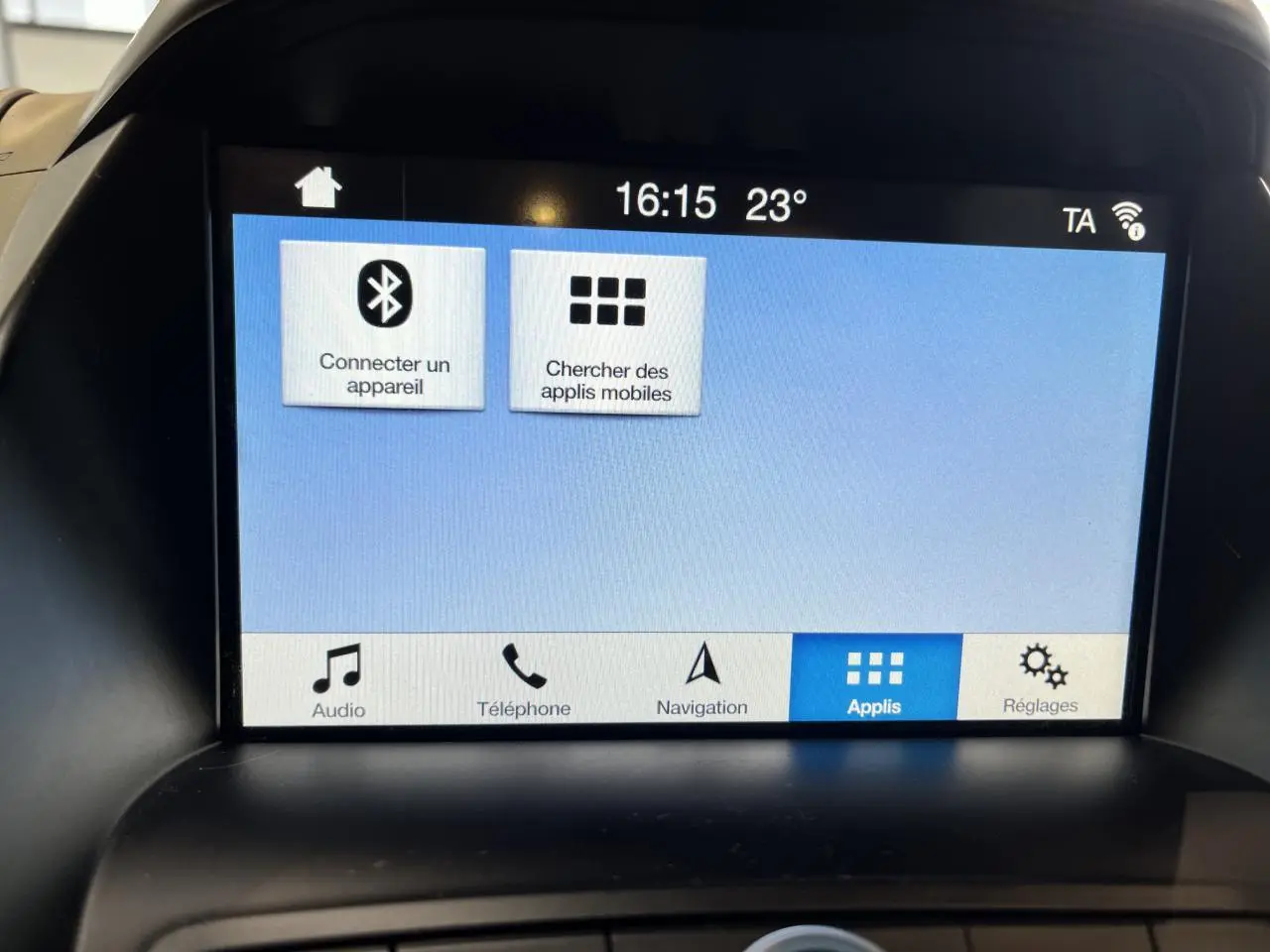 Écran tactile central de la Ford C-MAX blanc, affichant le menu des applications avec Bluetooth et navigation.