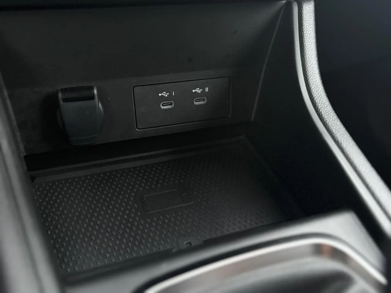 Gros plan sur la console centrale noire du Renault Captur 2025, montrant les ports USB-C doubles et un espace de charge sans fil.