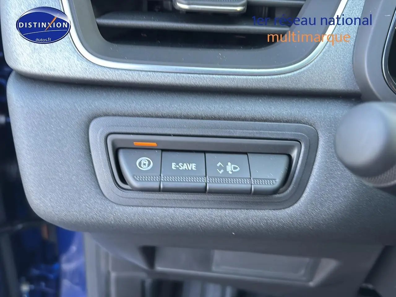 Gros plan sur les commandes E-SAVE et réglage des phares du tableau de bord du Renault Captur bleu iron.