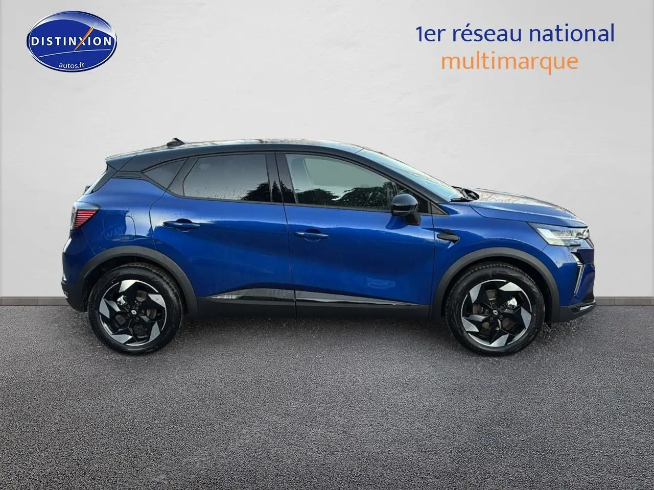 Vue latérale droite d'un Renault Captur 2026 bleu iron avec toit noir, jantes alliage et vitres surteintées.