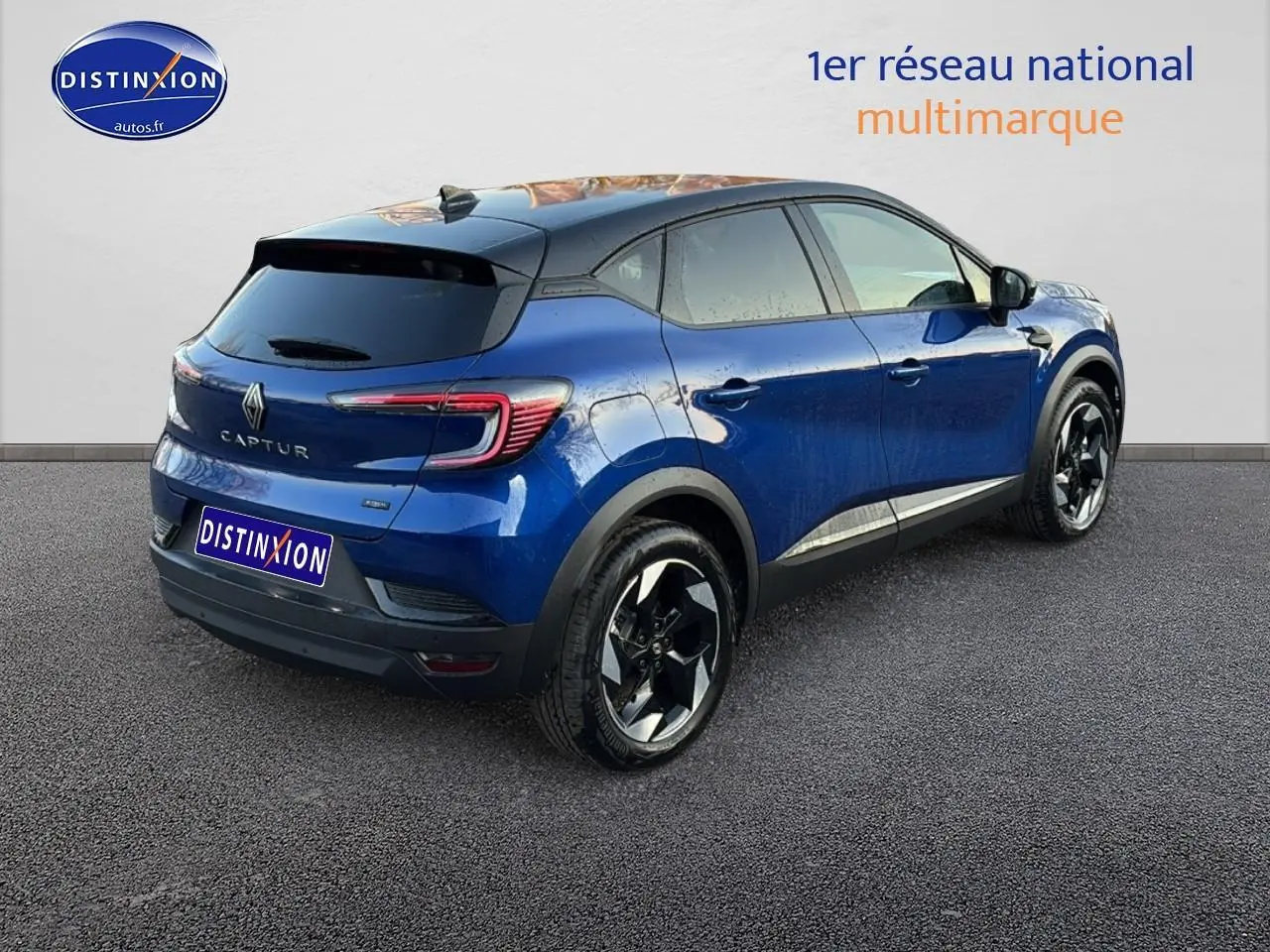 Renault Captur 2026 bleu iron et noir, vue 3/4 arrière droit, jantes alu noires et toit noir contrasté.