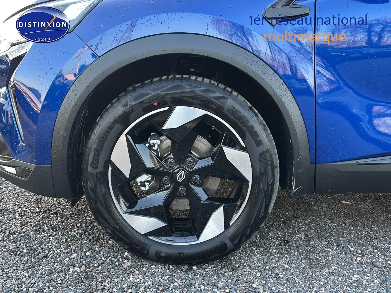Gros plan sur la roue avant gauche avec jante alu noire et argent sur Renault Captur bleu iron t/noir.
