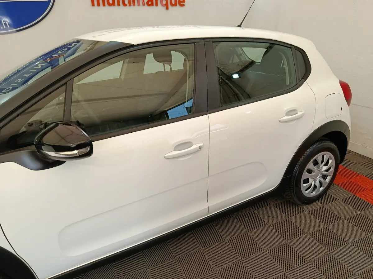 Profil droit d'une Citroën C3 blanche de 2020 avec rétroviseurs noirs et poignées de porte ton caisse.