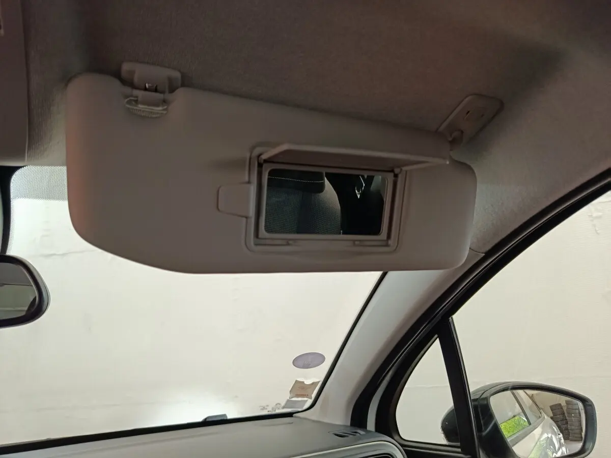 Détail intérieur montrant le pare-soleil côté conducteur avec miroir de courtoisie ouvert sur Citroën C3 blanche.