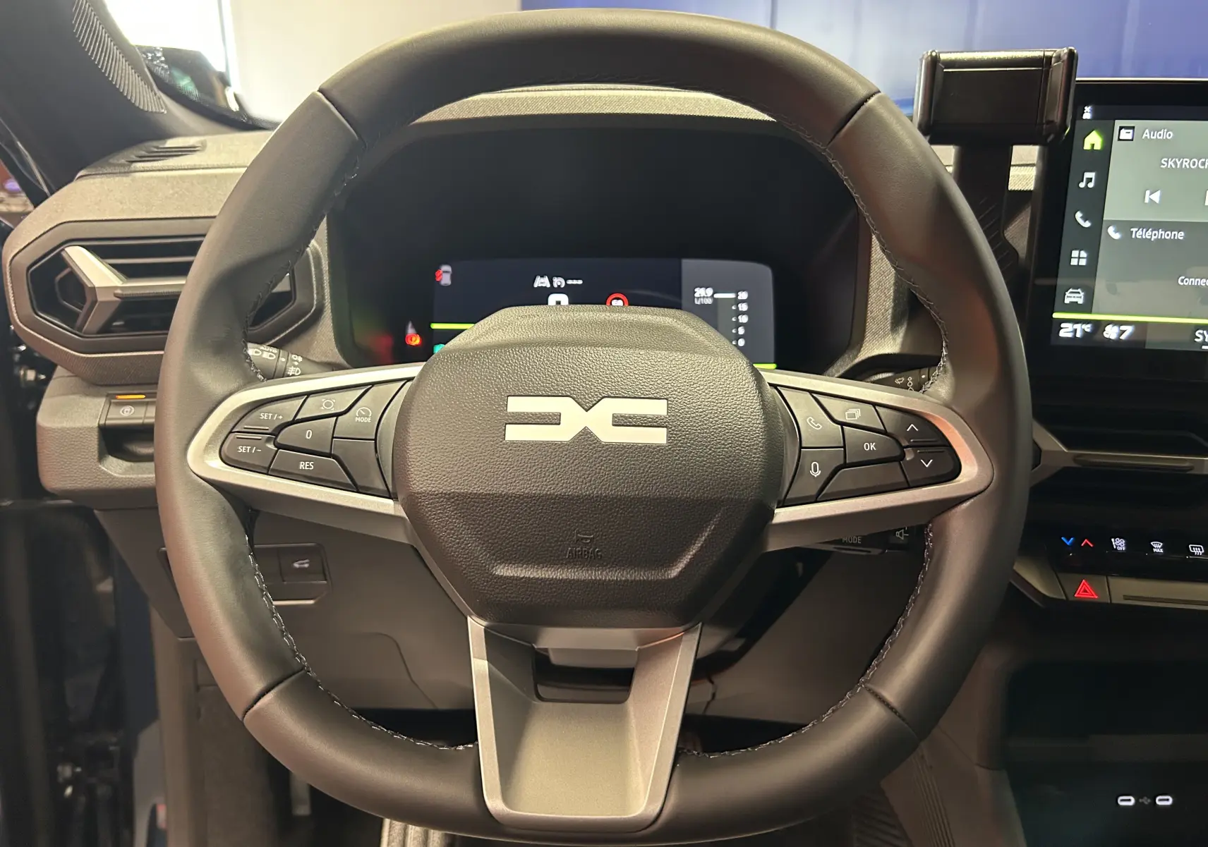 Vue rapprochée du volant multifonction noir du Dacia Bigster 2026 avec tableau de bord numérique et écran tactile.