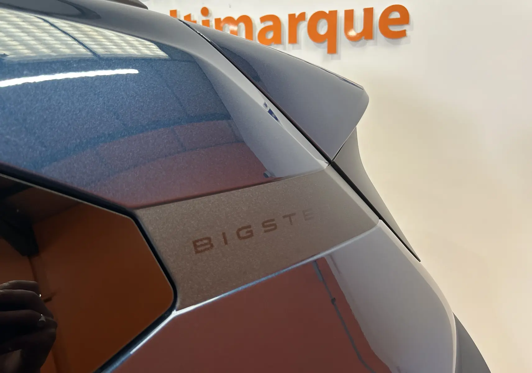 Détail du hayon arrière bleu indigo du Dacia Bigster 2026 avec logo discret et toit légèrement visible en arrière-plan.