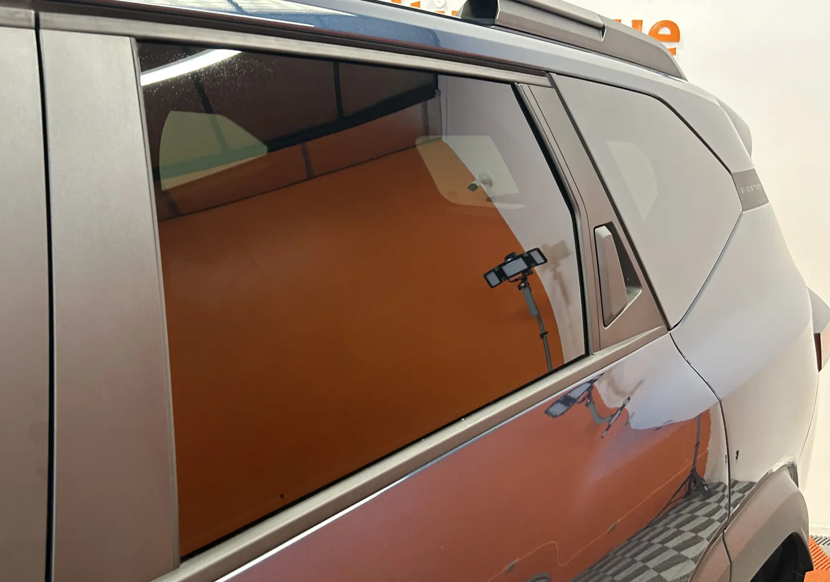 Vue latérale droite du Dacia Bigster bleu indigo, mettant en valeur la porte arrière et la vitre teintée.