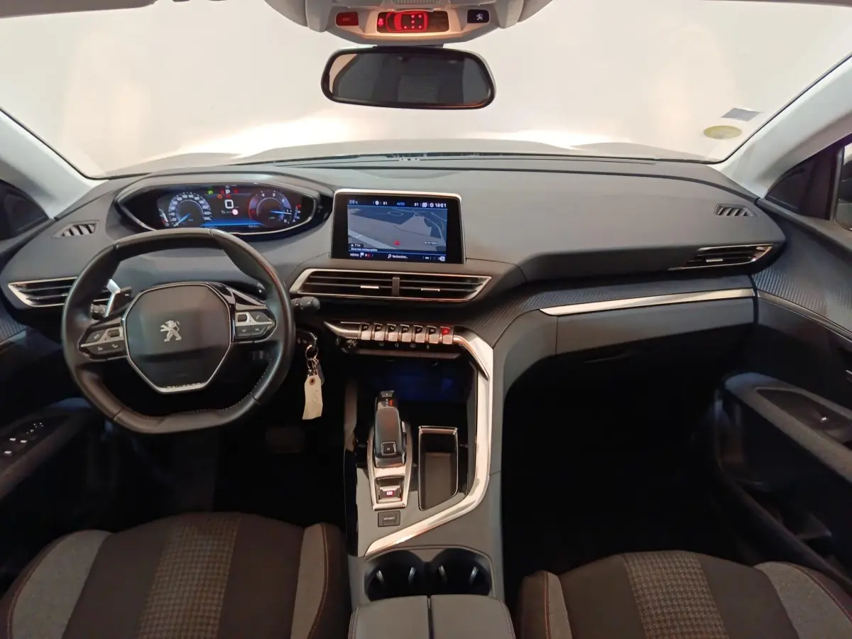 Vue intérieure avant du tableau de bord et volant cuir noir du Peugeot 5008 avec écran tactile central et commandes modernes.