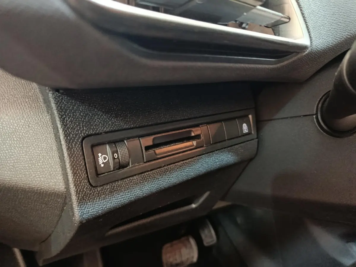 Détail du tableau de bord côté conducteur du Peugeot 5008 noir, avec commande réglage hauteur phares et verrouillage centralisé.
