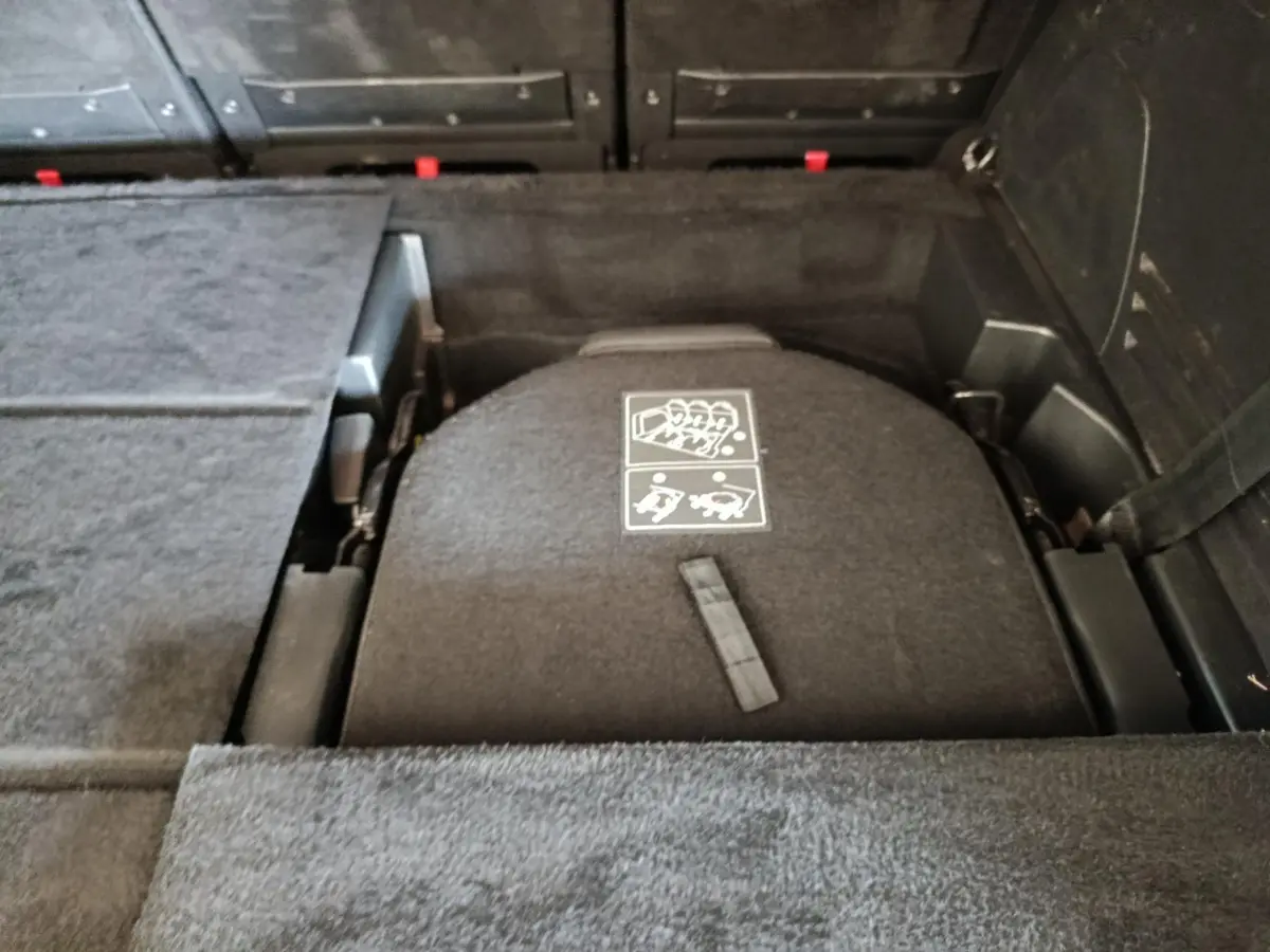 Vue rapprochée du coffre du Peugeot 5008 noir, montrant le plancher plat avec sièges arrière rabattus.
