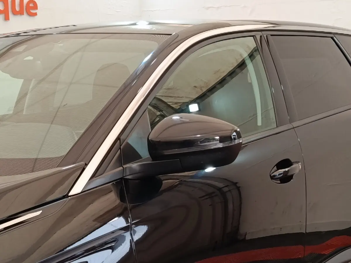 Vue rapprochée du côté gauche avant du Peugeot 5008 noir, mettant en valeur le rétroviseur et la portière.