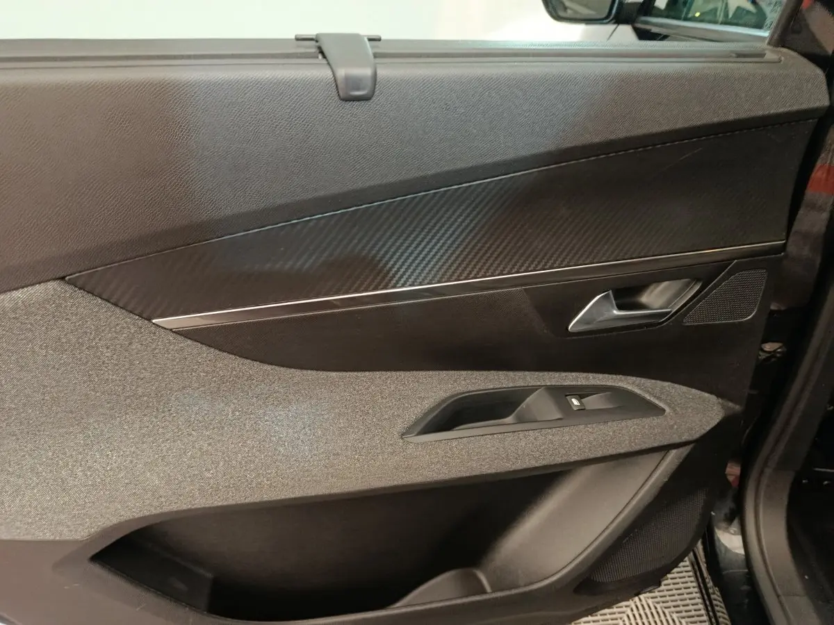 Détail de la porte avant gauche noire du Peugeot 5008 2020 avec insert effet carbone et commande de vitre.