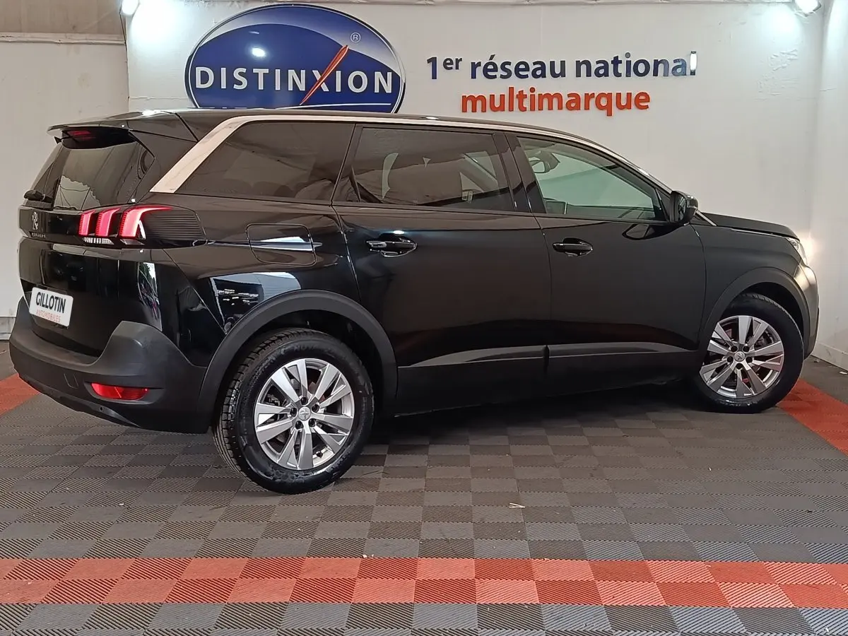 Peugeot 5008 noir vue de profil côté gauche en intérieur avec feux arrière à LED et jantes alliage.