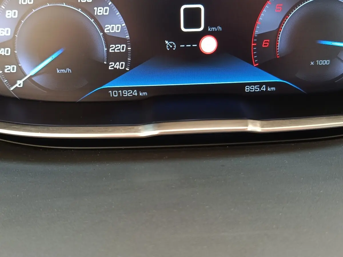 Gros plan sur le tableau de bord numérique du Peugeot 5008 noir, affichant la vitesse et le compteur kilométrique.