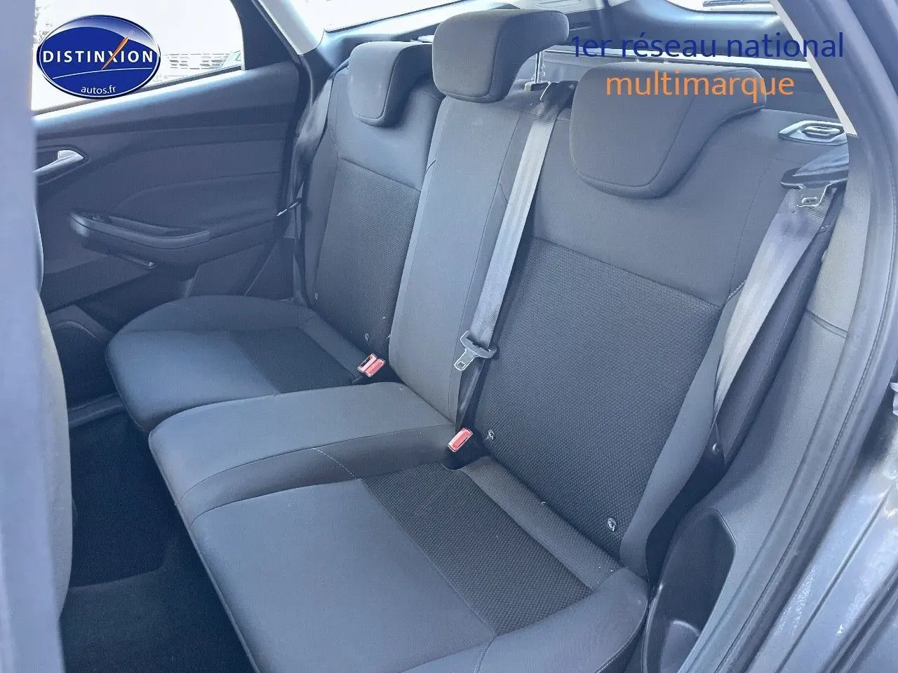 Vue intérieure des sièges arrière en tissu noir du Ford Focus SW 2018, côté droit avec ceinture attachée.