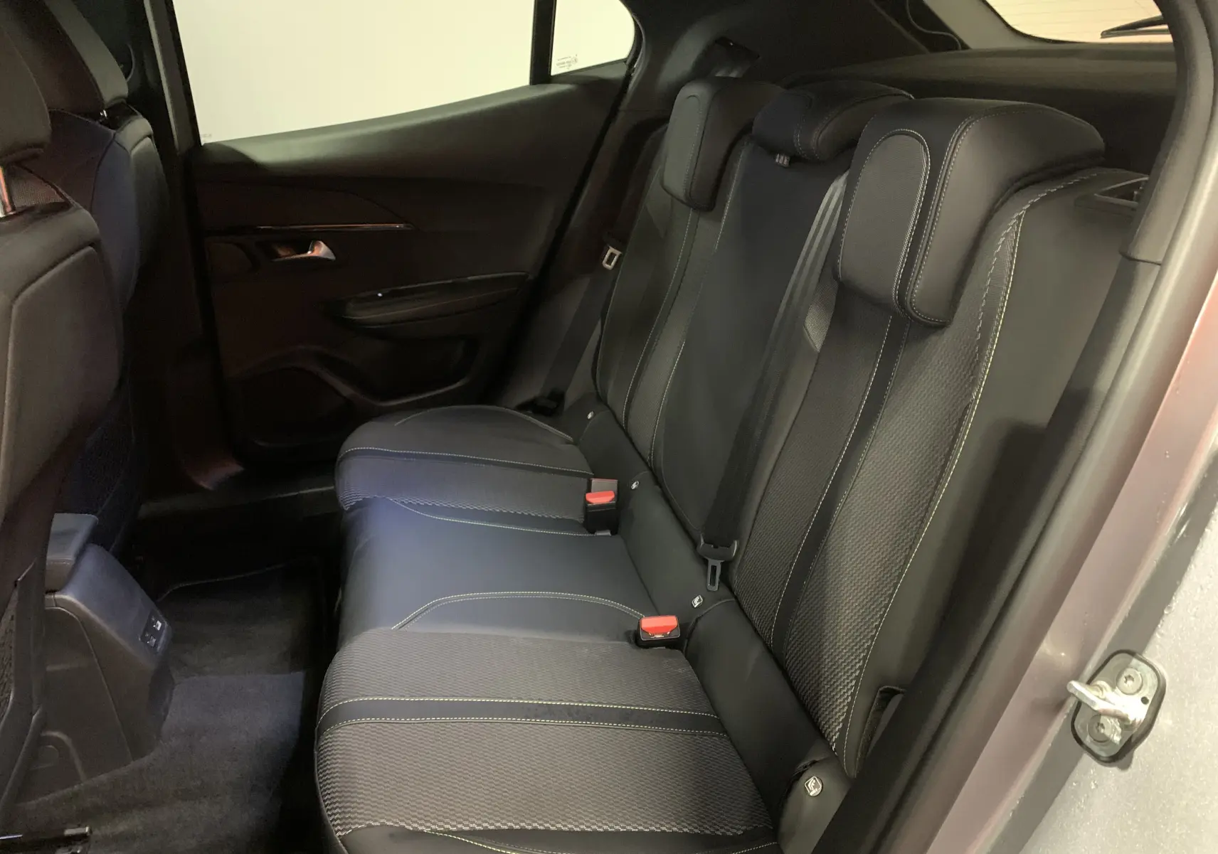 Vue intérieure côté droit des sièges arrière en cuir noir avec surpiqûres contrastantes du Peugeot 2008 gris 2023.
