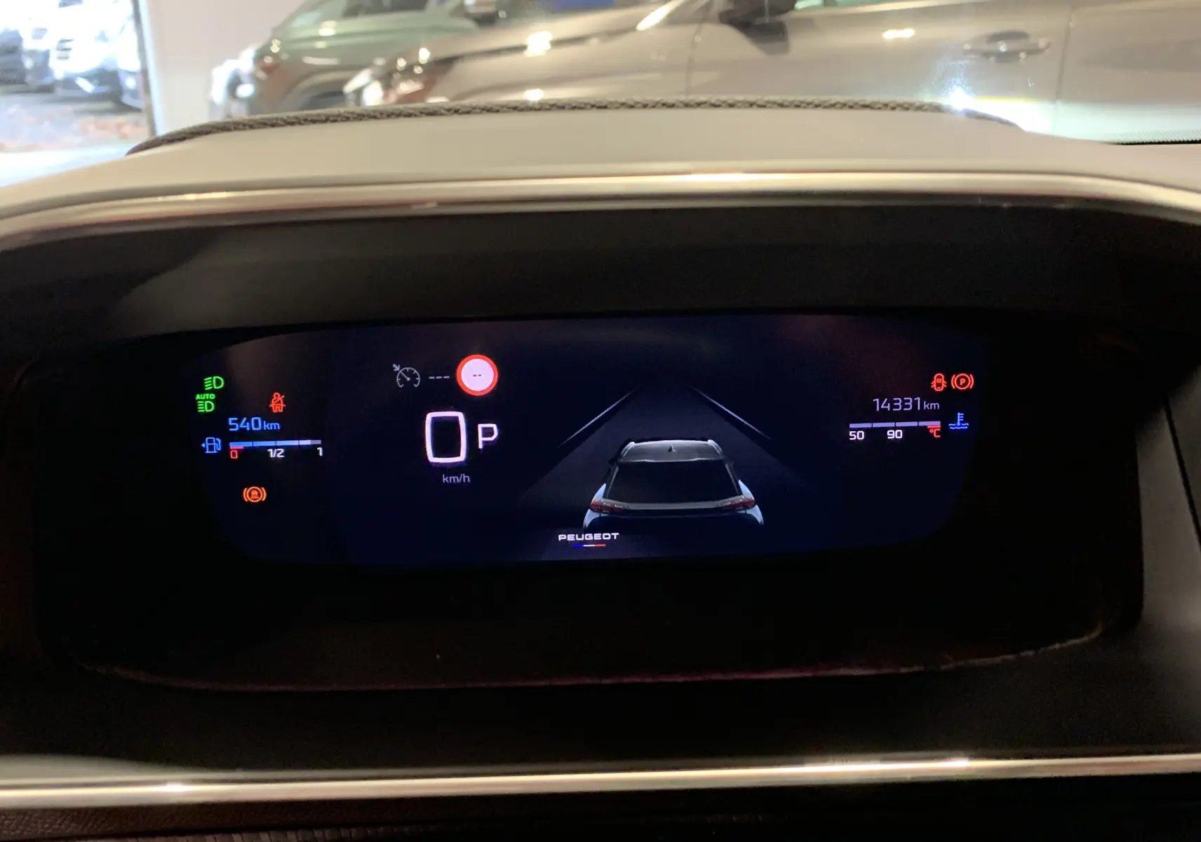 Affichage numérique du tableau de bord du Peugeot 2008 gris, montrant la voiture en position stationnaire et les indicateurs de vitesse et kilométrage.