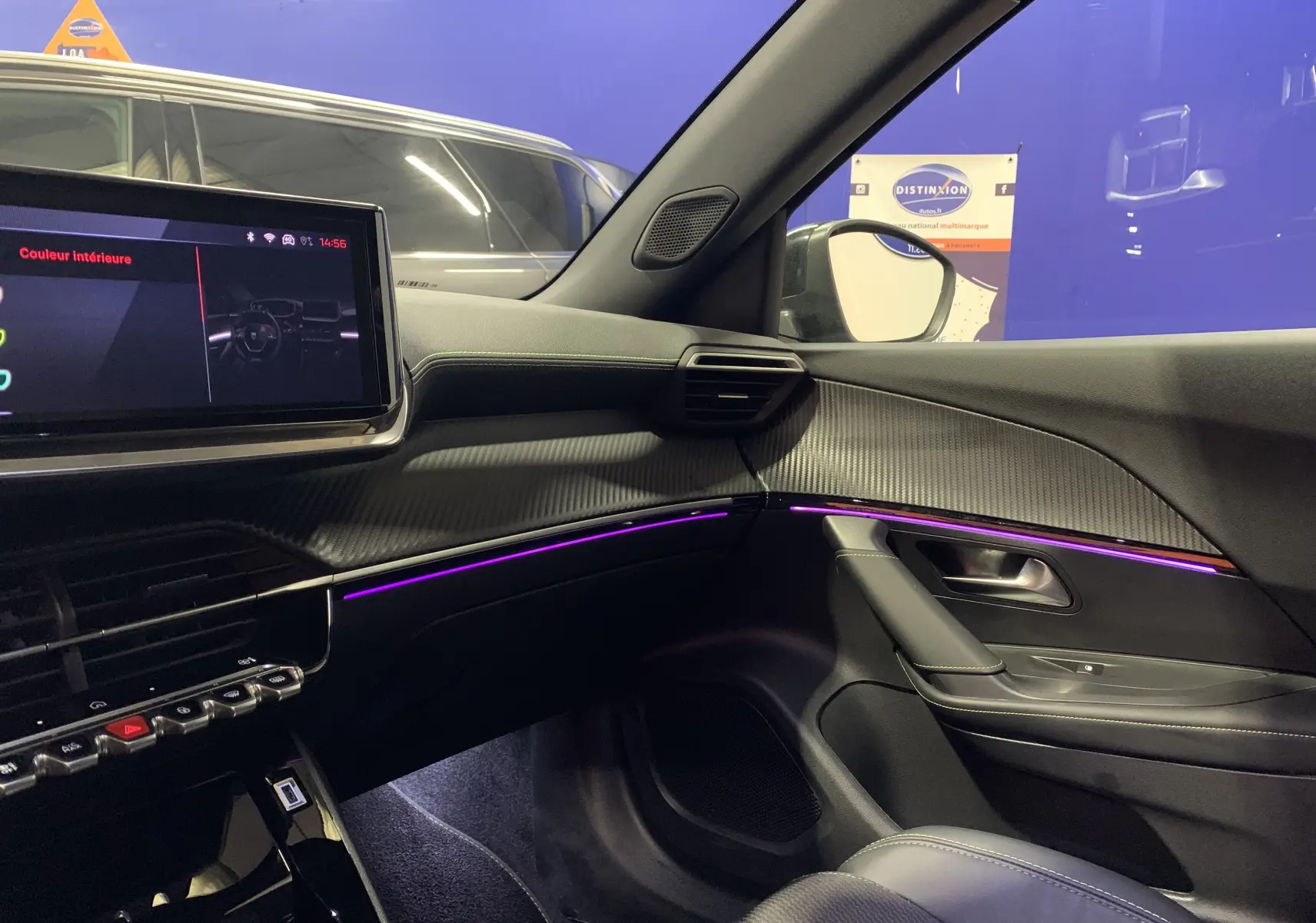 Intérieur côté passager du Peugeot 2008 gris 2023, avec éclairage d'ambiance violet et tableau de bord moderne.
