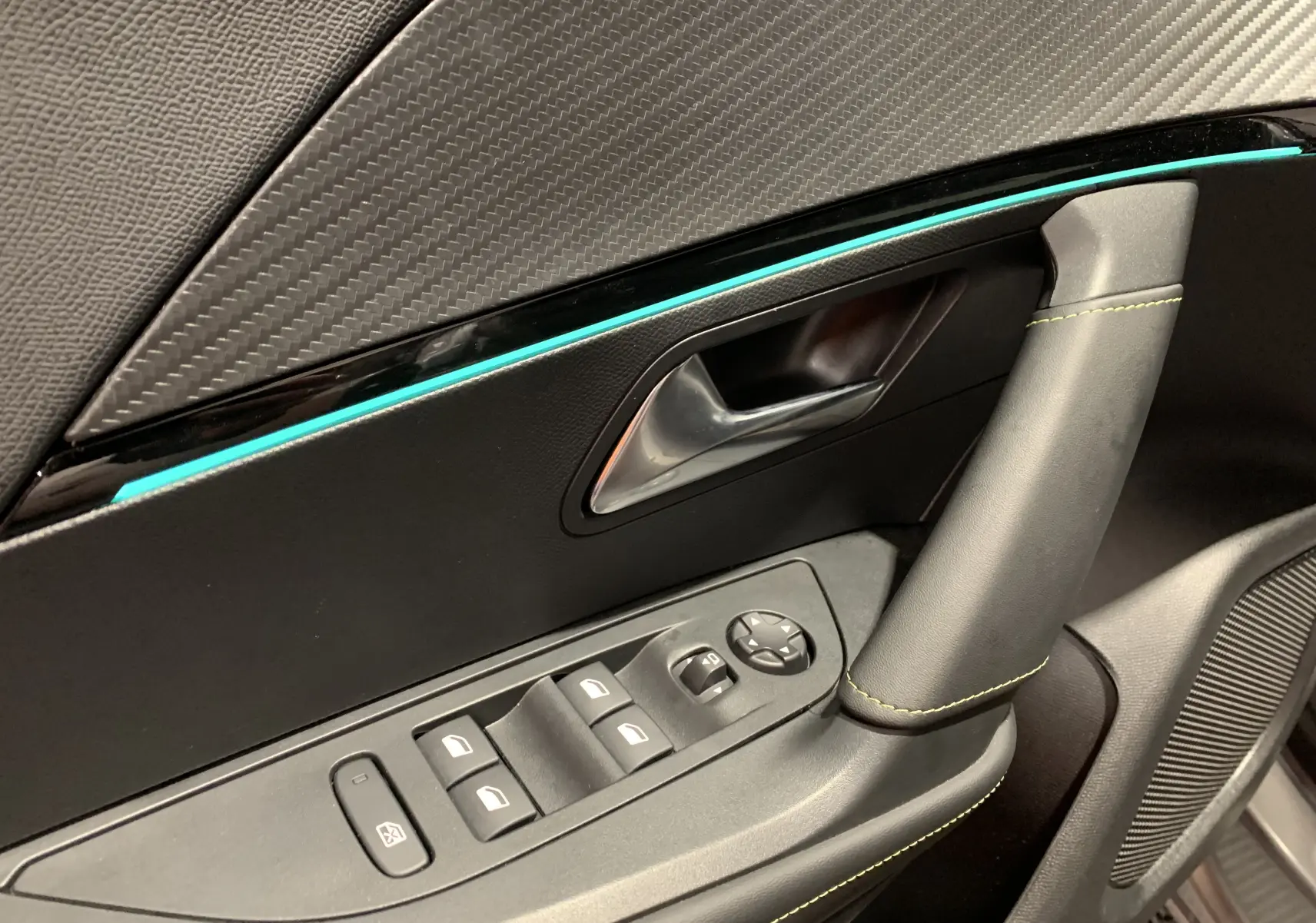 Gros plan sur la porte côté gauche du Peugeot 2008 gris 2023, avec commandes de vitres et insert décoratif bleu clair.