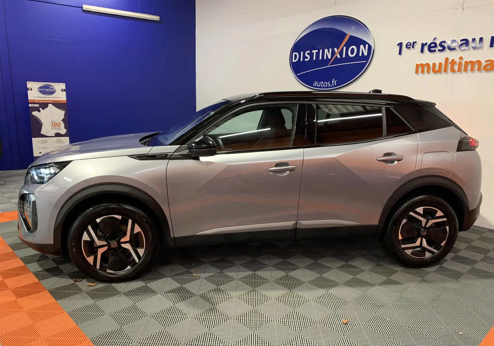 Profil côté gauche du Peugeot 2008 BlueHDi 130 GT gris 2023 avec toit noir et jantes alliage distinctives.