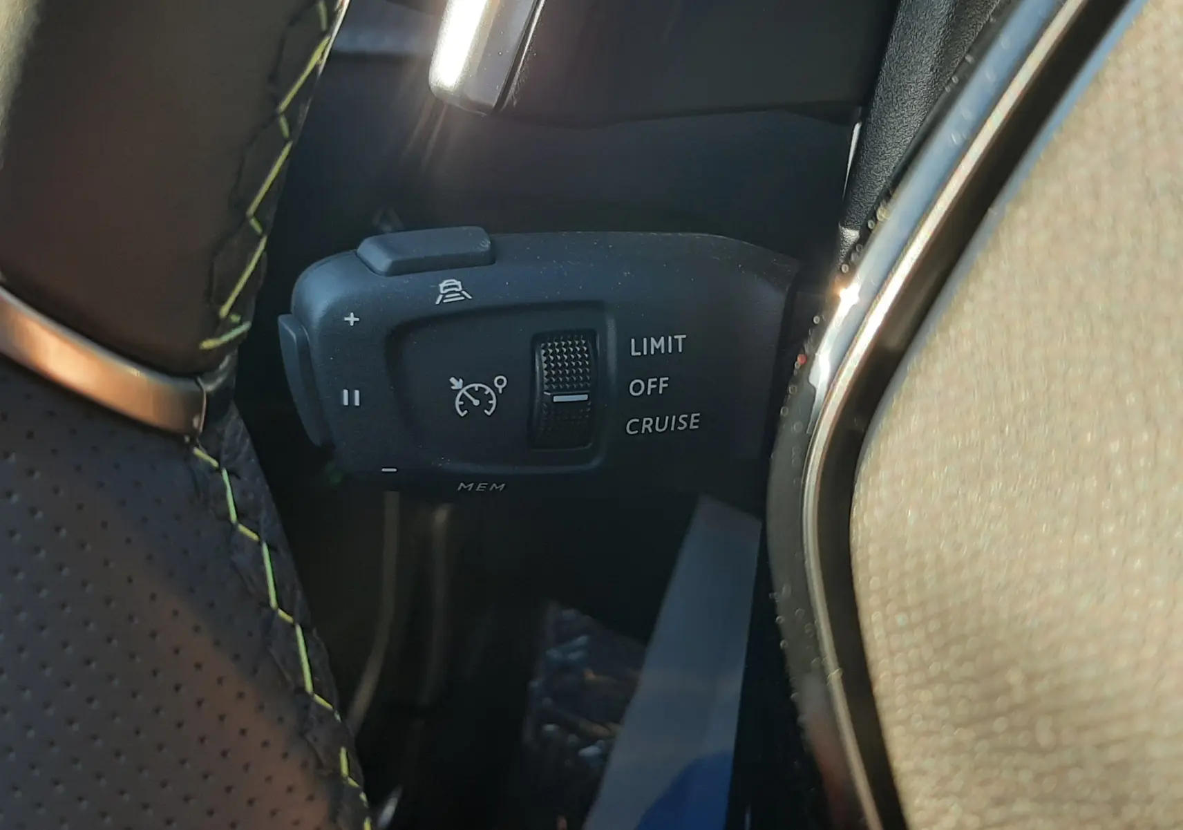 Gros plan sur la commande de régulateur de vitesse à gauche du volant dans l'habitacle du Peugeot 2008 gris selenium.