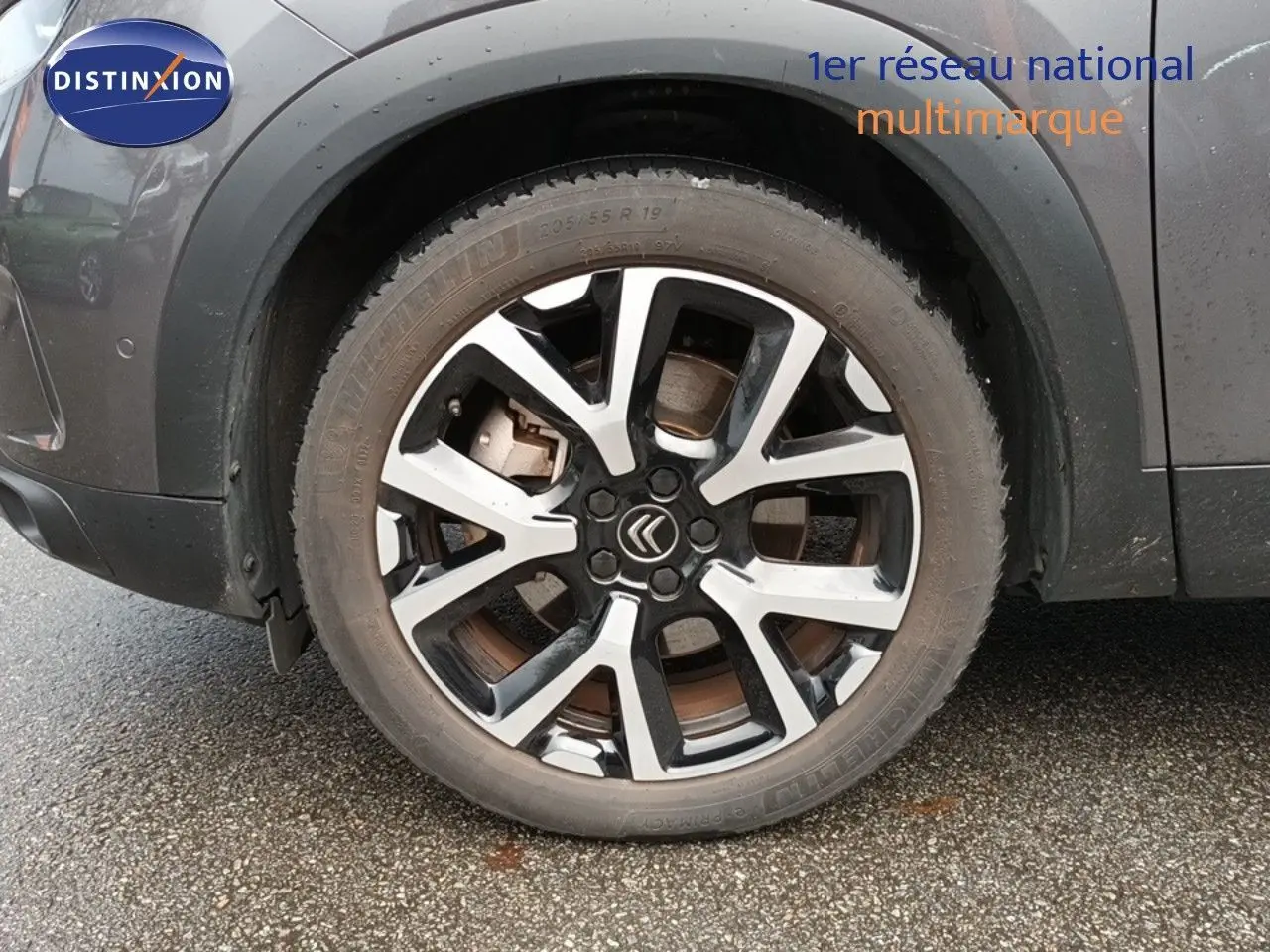 Gros plan sur la roue avant gauche d’un Citroën C5 Aircross gris platinium avec jante alliage bicolore.